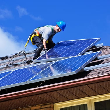 Man installs solar panel atop house roof