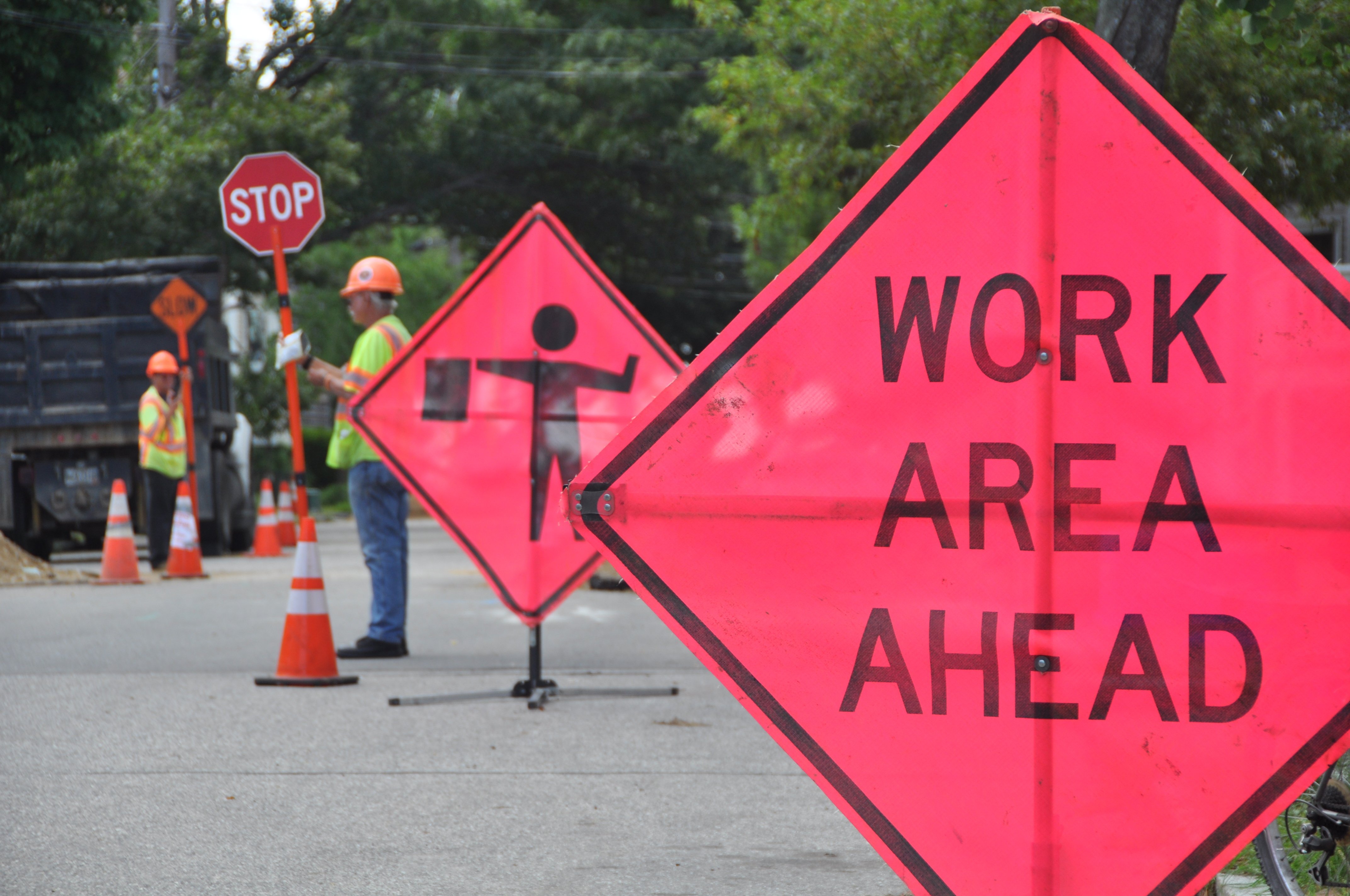 Road work with city employees and "Work area ahead" sign