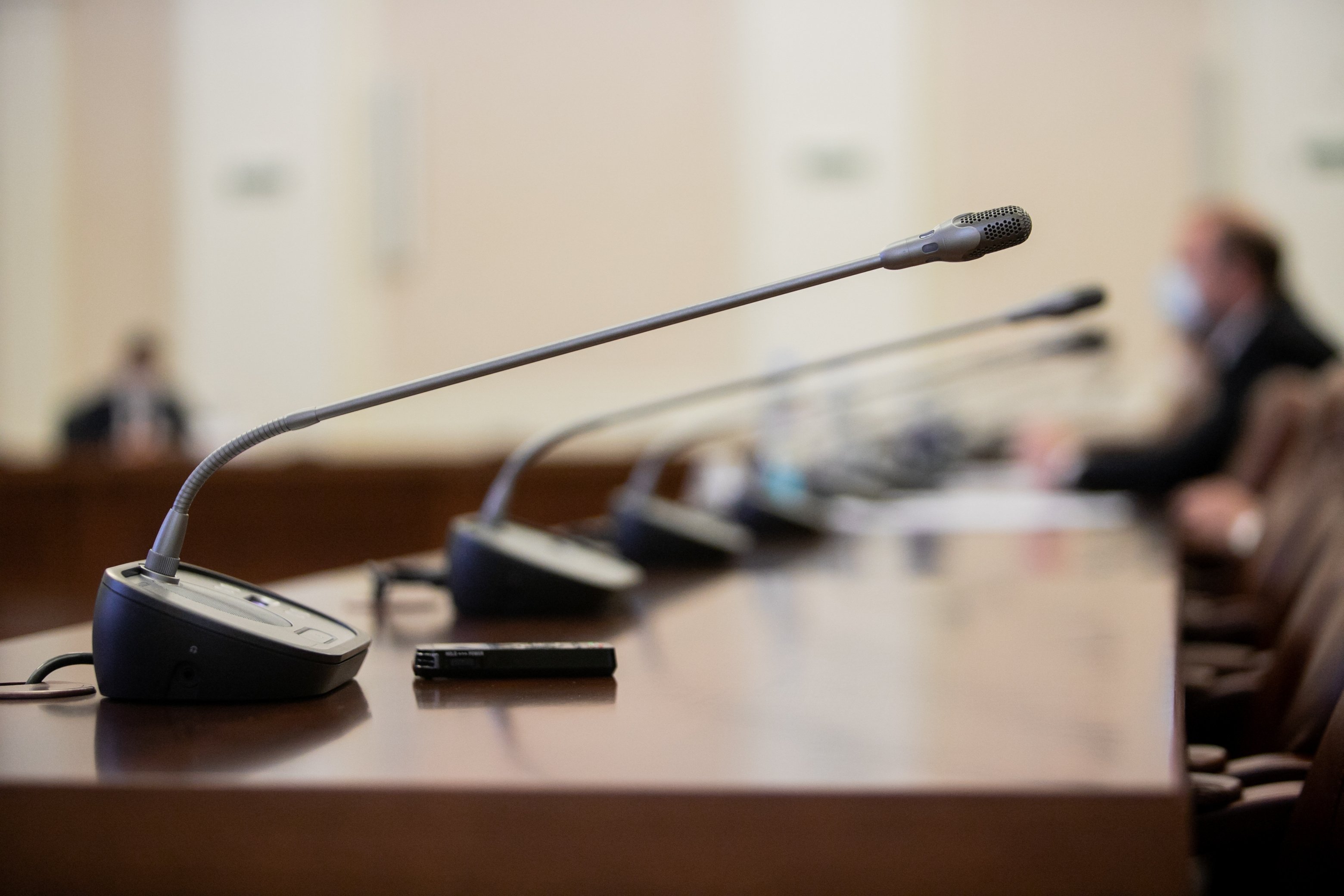 Row of microphones at a City Hall meeting.