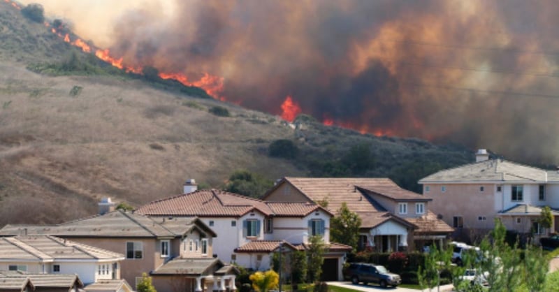 Wildfires threaten a hillside community. 
