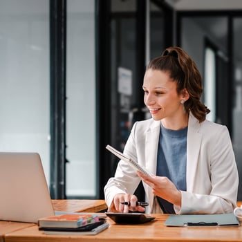 Woman looking at laptop sitting at desk