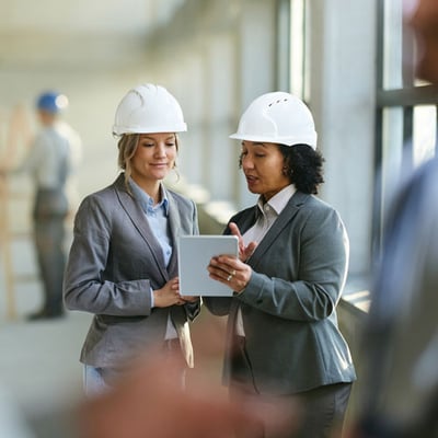 Women viewing tablet in building