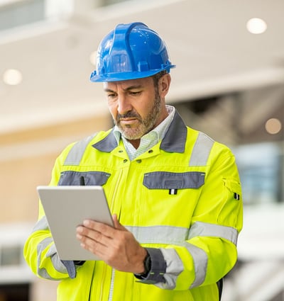 Guy looking at tablet on job site