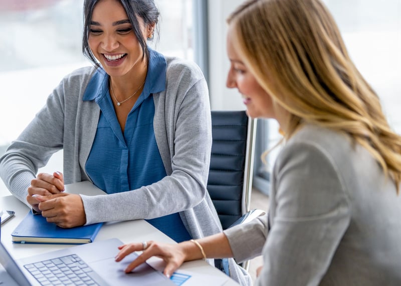 Coworkers reviewing permit on laptop