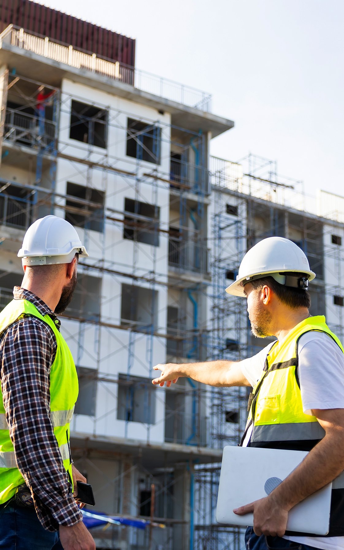Two workers in front of construction