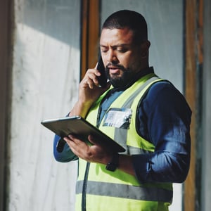 Man reviewing plans on tablet and phone