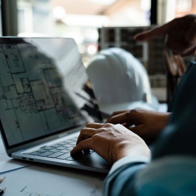 Man using laptop to review plans
