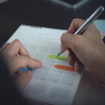 Hands marking calendar dates