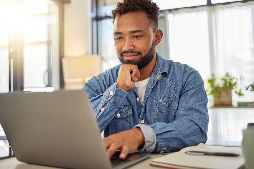 man on laptop reviewing permits