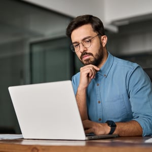 man reviewing permits on laptop