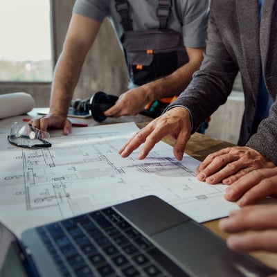 review-team-looking-at-documents-and-plans-at-desk