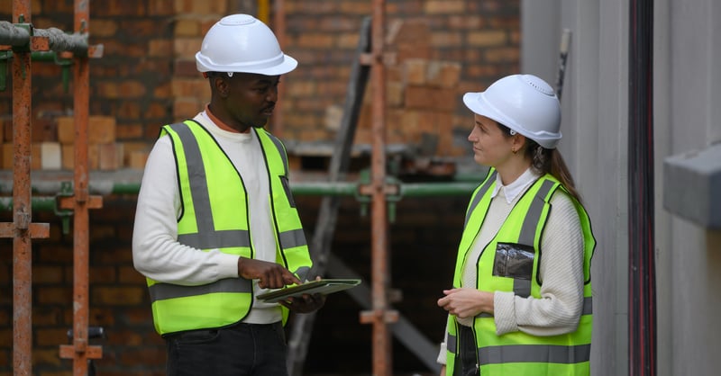 Two construction members talking on job site